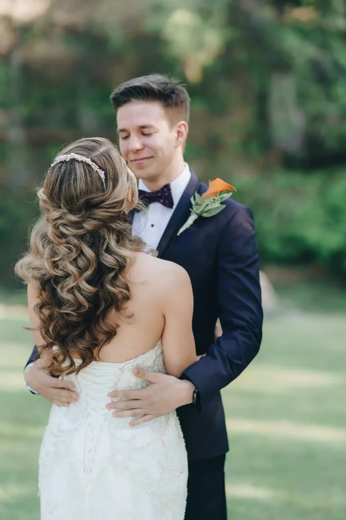 Wedding portrait with bride facing groom, with long curly waves visible