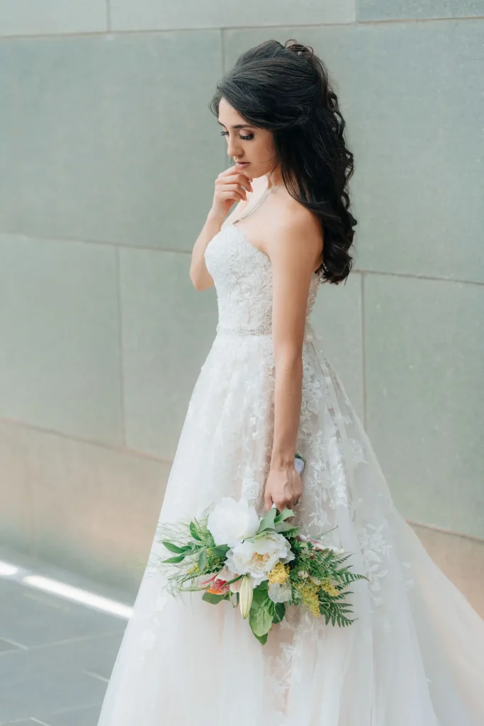 Bride posing for portrait on wedding day, with glam hair and makeup by Marci Madla